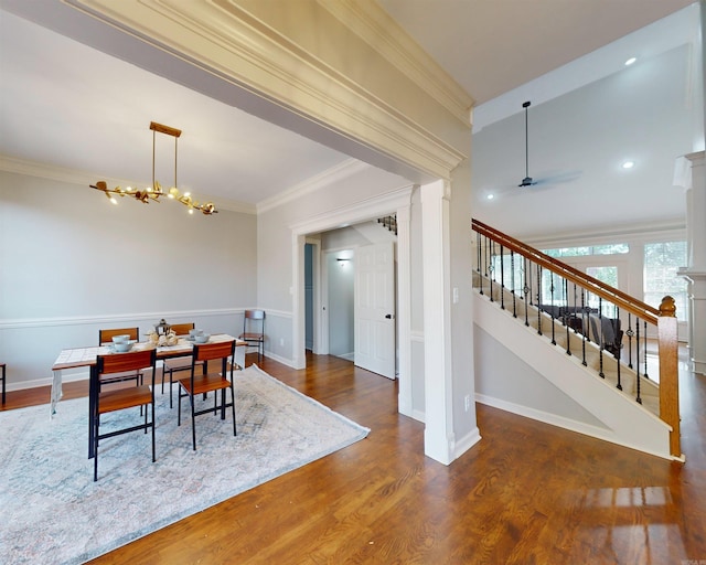 dining room featuring crown molding, baseboards, stairs, and wood finished floors