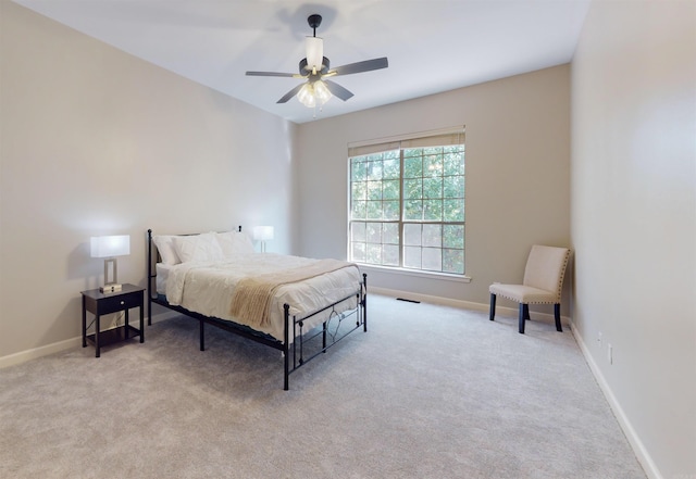 bedroom featuring baseboards, light colored carpet, ceiling fan, and visible vents
