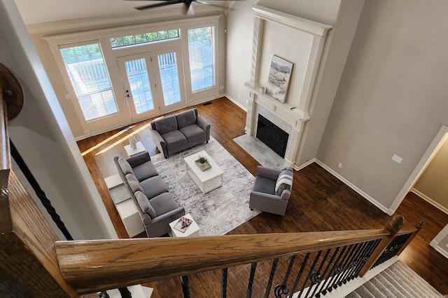 living room with a premium fireplace, baseboards, a ceiling fan, and wood finished floors