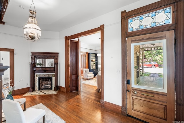 1509 S Spring, Little Rock, AR 72202 - living room featuring baseboards, wood finished floors, a fireplace, and an inviting chandelier