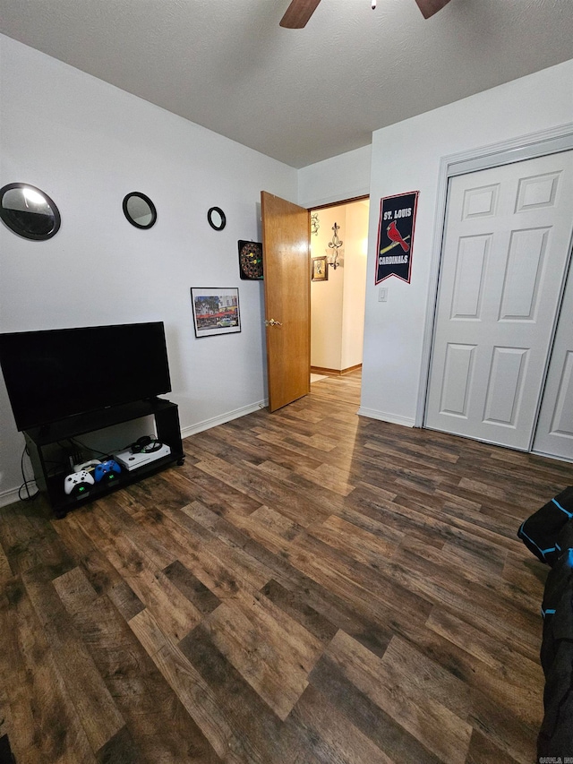 living area with baseboards, a ceiling fan, and wood finished floors