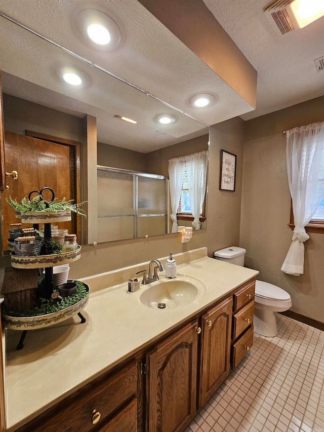 full bathroom with vanity, visible vents, toilet, a textured ceiling, and a shower stall