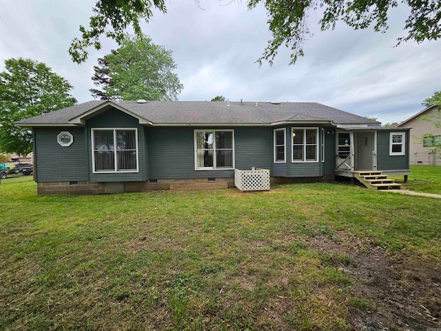 rear view of property with a lawn, a shingled roof, and crawl space