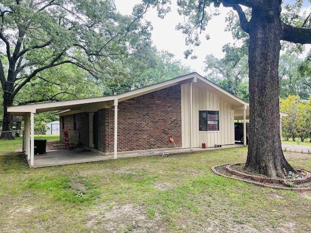 view of home's exterior featuring brick siding, board and batten siding, fence, and a lawn