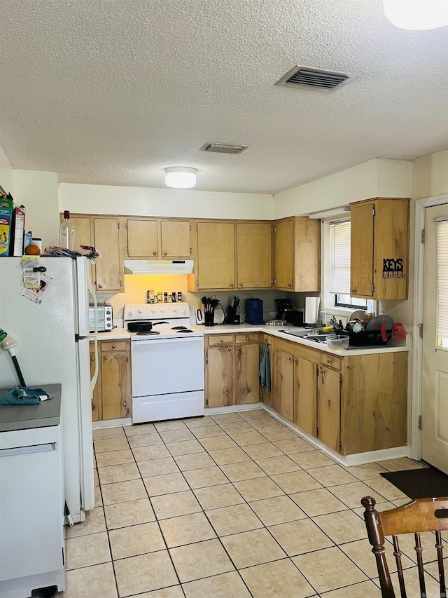 kitchen with a textured ceiling, visible vents, light countertops, under cabinet range hood, and white appliances