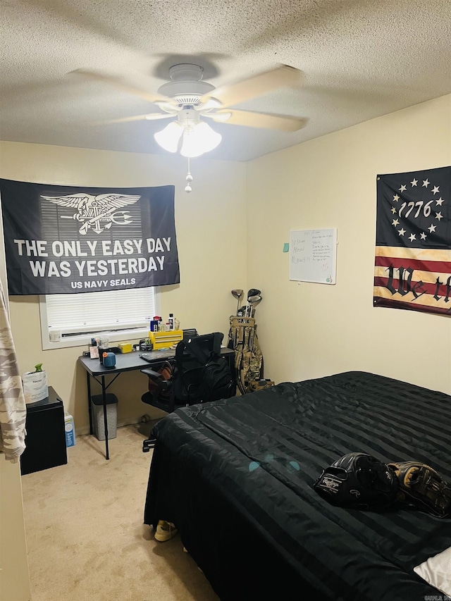 carpeted bedroom featuring a ceiling fan and a textured ceiling