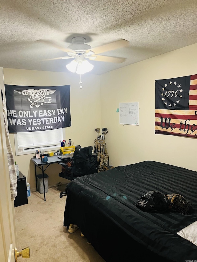 carpeted bedroom featuring a ceiling fan and a textured ceiling