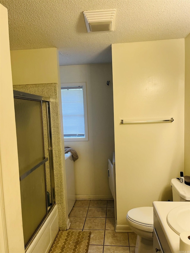 bathroom with a textured ceiling, visible vents, tile patterned flooring, vanity, and toilet