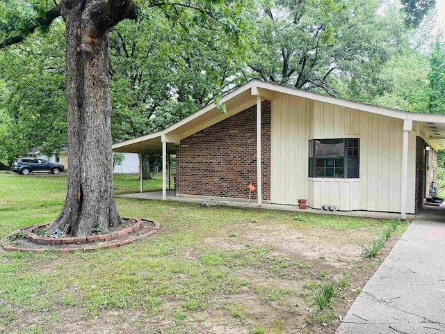 view of property exterior with board and batten siding, a lawn, and brick siding