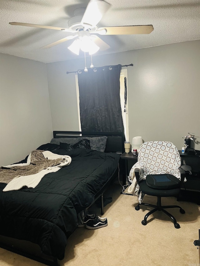 carpeted bedroom with a ceiling fan and a textured ceiling