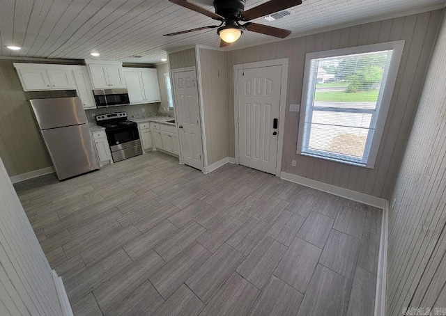 kitchen featuring a ceiling fan, visible vents, wood finish floors, stainless steel appliances, and white cabinetry