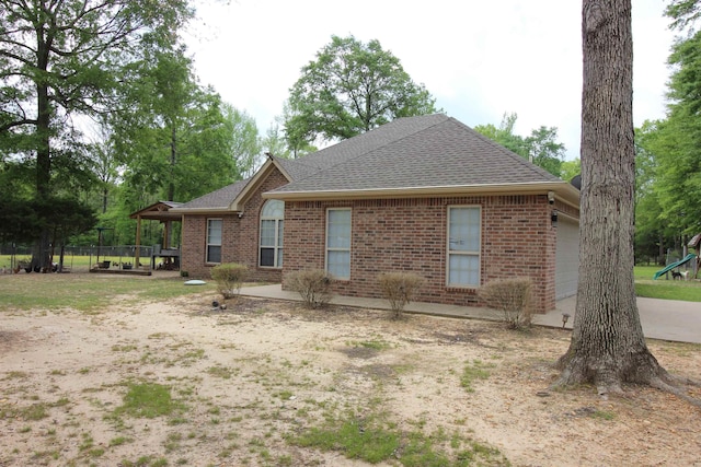 24076 Gracie Layne Ln, Bauxite, AR 72011 - view of home's exterior featuring brick siding, a shingled roof, and an attached garage