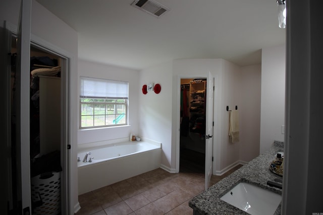 24076 Gracie Layne Ln, Bauxite, AR 72011 - full bathroom with a walk in closet, a sink, tile patterned floors, visible vents, and a garden tub