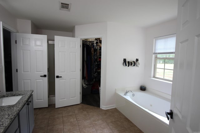 24076 Gracie Layne Ln, Bauxite, AR 72011 - full bath featuring a walk in closet, vanity, tile patterned floors, a whirlpool tub, and visible vents