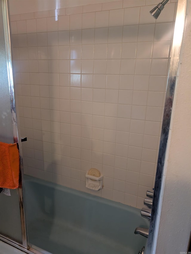 full bath featuring combined bath / shower with glass door