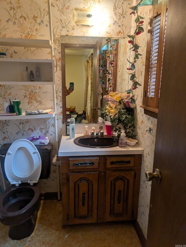 bathroom featuring vanity, toilet, and wallpapered walls