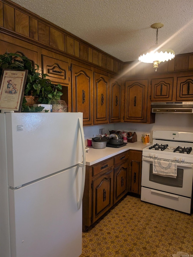 kitchen featuring white appliances, light countertops, a textured ceiling, light floors, and under cabinet range hood