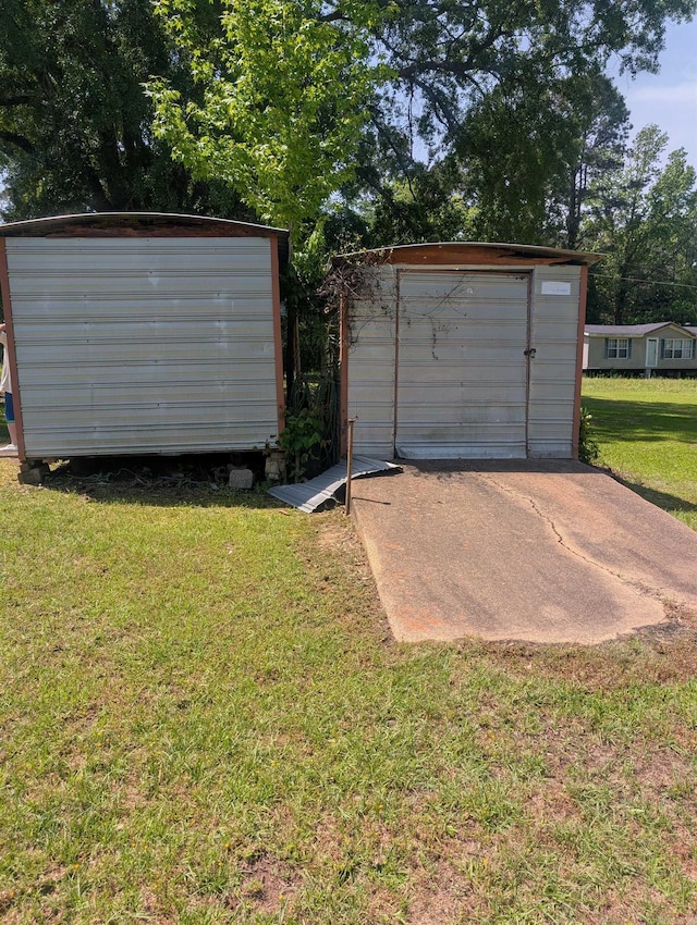 detached garage featuring concrete driveway and a shed