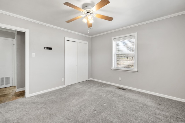 unfurnished bedroom featuring baseboards, visible vents, ornamental molding, and carpet