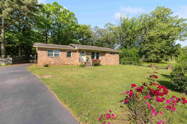 ranch-style house featuring crawl space, a front yard, brick siding, fence, and aphalt driveway