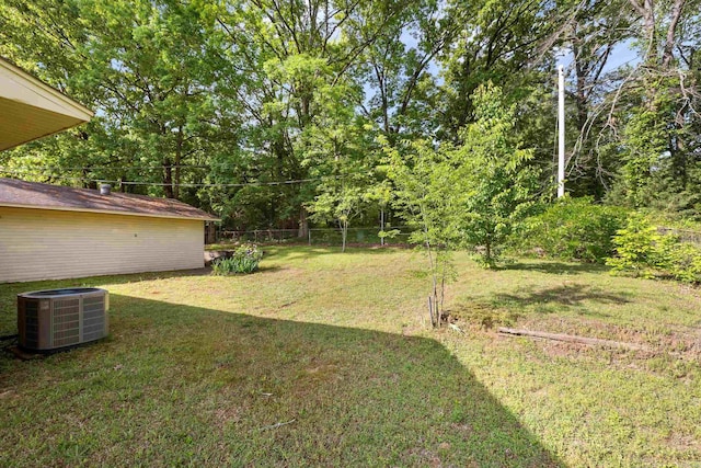 view of yard with central AC and fence