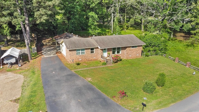 view of front of home featuring brick siding, aphalt driveway, and a front lawn