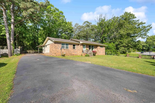 ranch-style house with fence, a front yard, and brick siding