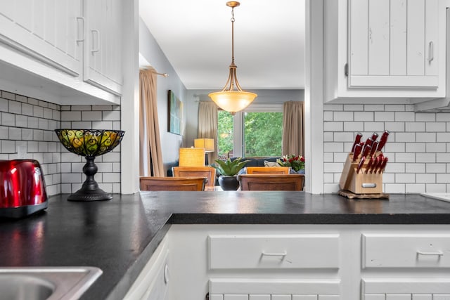 350 Peters Pt Unit L1, Hot Springs, AR 71913 - kitchen with decorative backsplash, white cabinets, dark countertops, and hanging light fixtures