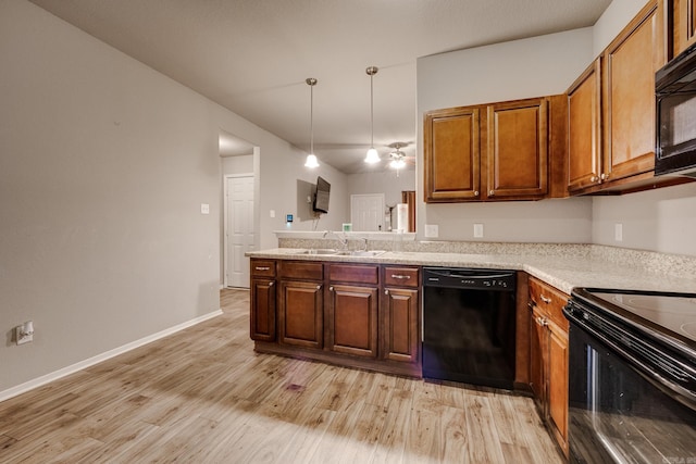 kitchen with brown cabinets, a sink, light wood finished floors, light countertops, and black appliances