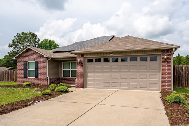 single story home featuring concrete driveway, brick siding, an attached garage, and fence