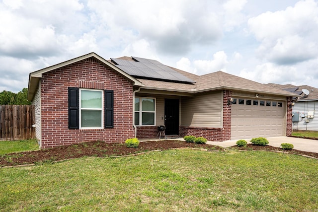 single story home with solar panels, a garage, brick siding, fence, and concrete driveway