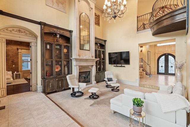 living room with a high ceiling, a notable chandelier, a fireplace, baseboards, and stairway