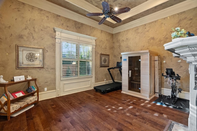 exercise room featuring ornamental molding, a raised ceiling, ceiling fan, and hardwood / wood-style flooring