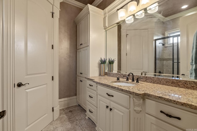 full bath with vanity, baseboards, crown molding, and a shower stall