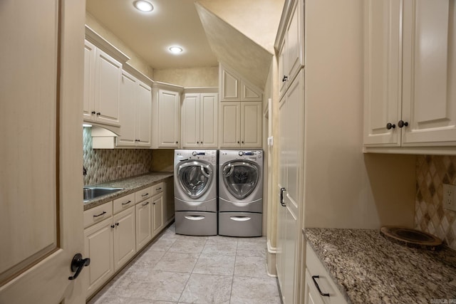 laundry room featuring washer and dryer, recessed lighting, a sink, and cabinet space