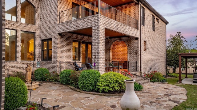 property entrance featuring brick siding and a balcony