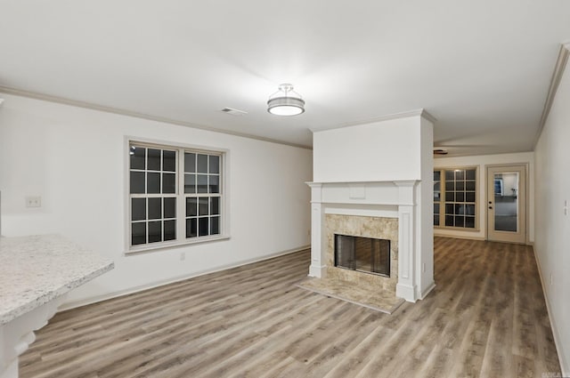 unfurnished living room with a premium fireplace, visible vents, and wood finished floors