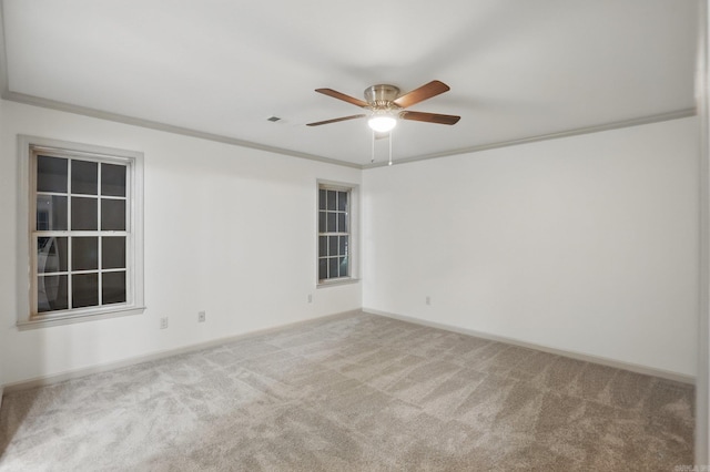 empty room with carpet floors, a ceiling fan, baseboards, and ornamental molding