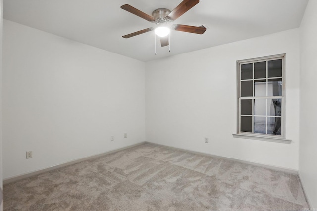 spare room with carpet flooring, ceiling fan, and baseboards