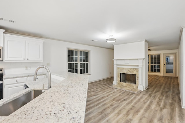 kitchen featuring white cabinetry, a sink, and light wood-style flooring
