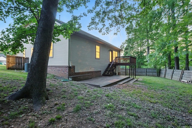 rear view of house featuring a wooden deck, a fenced backyard, stairs, central air condition unit, and a yard