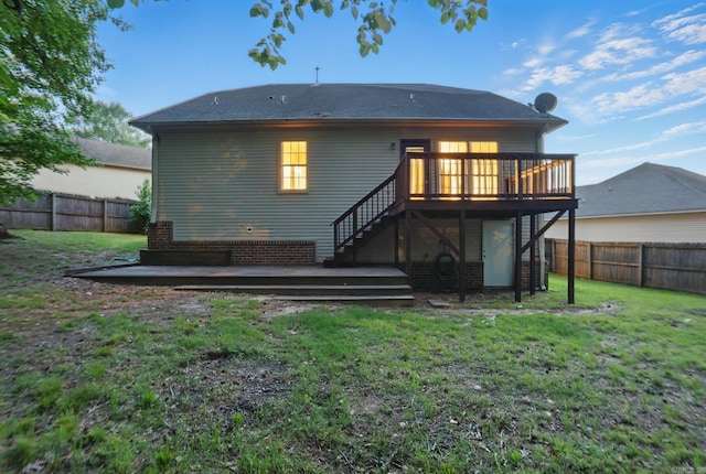 rear view of property with a fenced backyard, a wooden deck, a yard, and stairway
