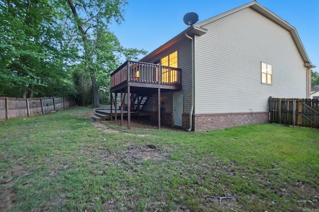 rear view of property with a yard, a wooden deck, a fenced backyard, and stairs