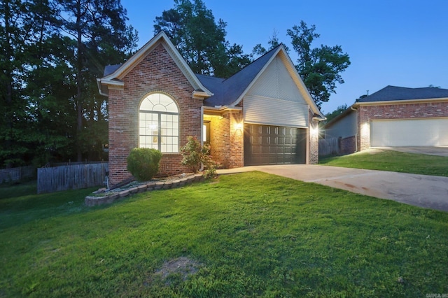 traditional home featuring brick siding, a garage, fence, and concrete driveway