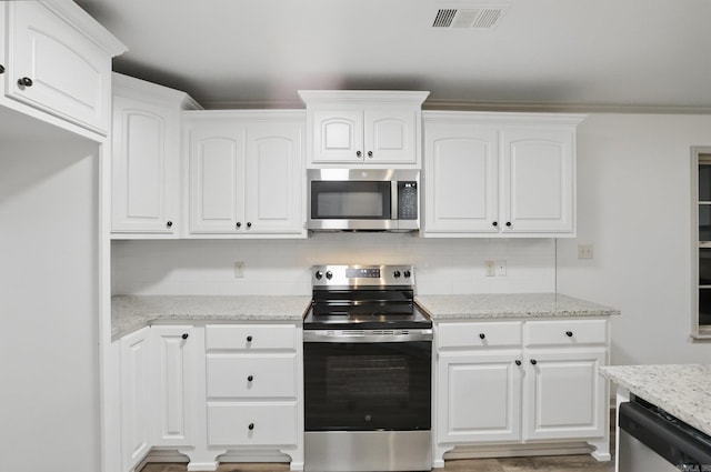 kitchen with light stone counters, stainless steel appliances, white cabinetry, tasteful backsplash, and visible vents
