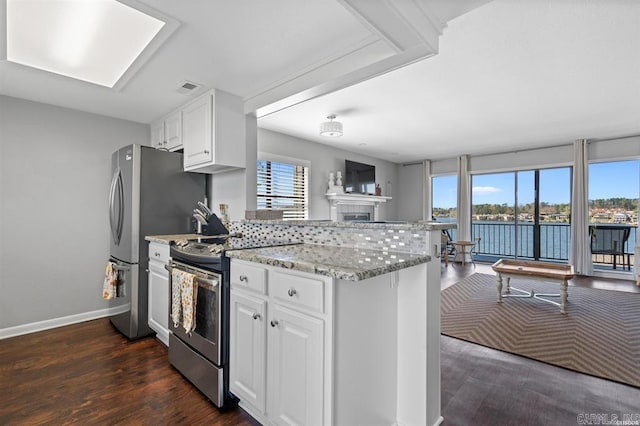 120 Catalina Cir Unit 2A, Hot Springs, AR 71913 - kitchen with a healthy amount of sunlight, appliances with stainless steel finishes, a tiled fireplace, and a peninsula