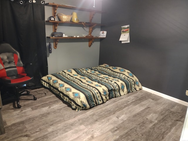 bedroom featuring baseboards and wood finished floors