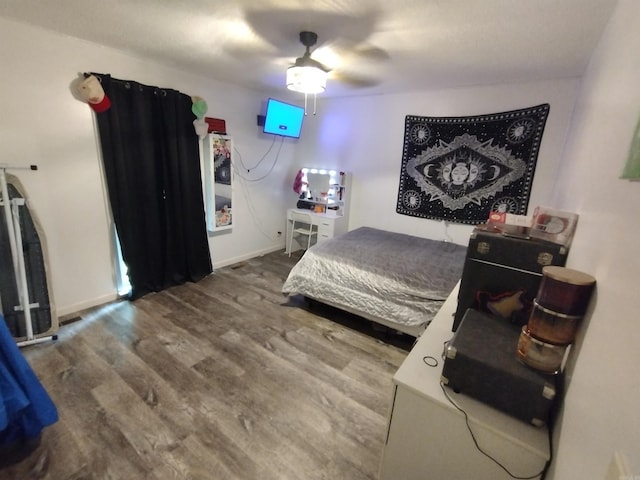 bedroom with a ceiling fan, baseboards, and wood finished floors