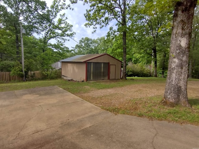 view of yard with an outdoor structure, a garage, and fence