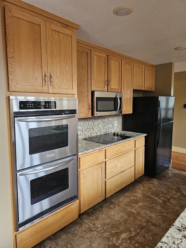 161 Funderburg Rd, Mineral Sprs, AR 71851 - kitchen featuring stone finish floor, decorative backsplash, a textured ceiling, light stone counters, and black appliances